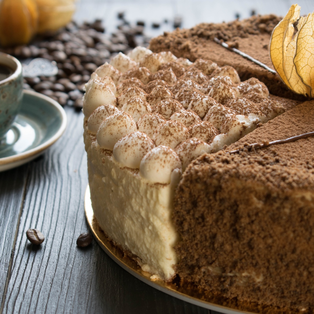 Вкусный торт с кремом и физалисом на столе с кофе