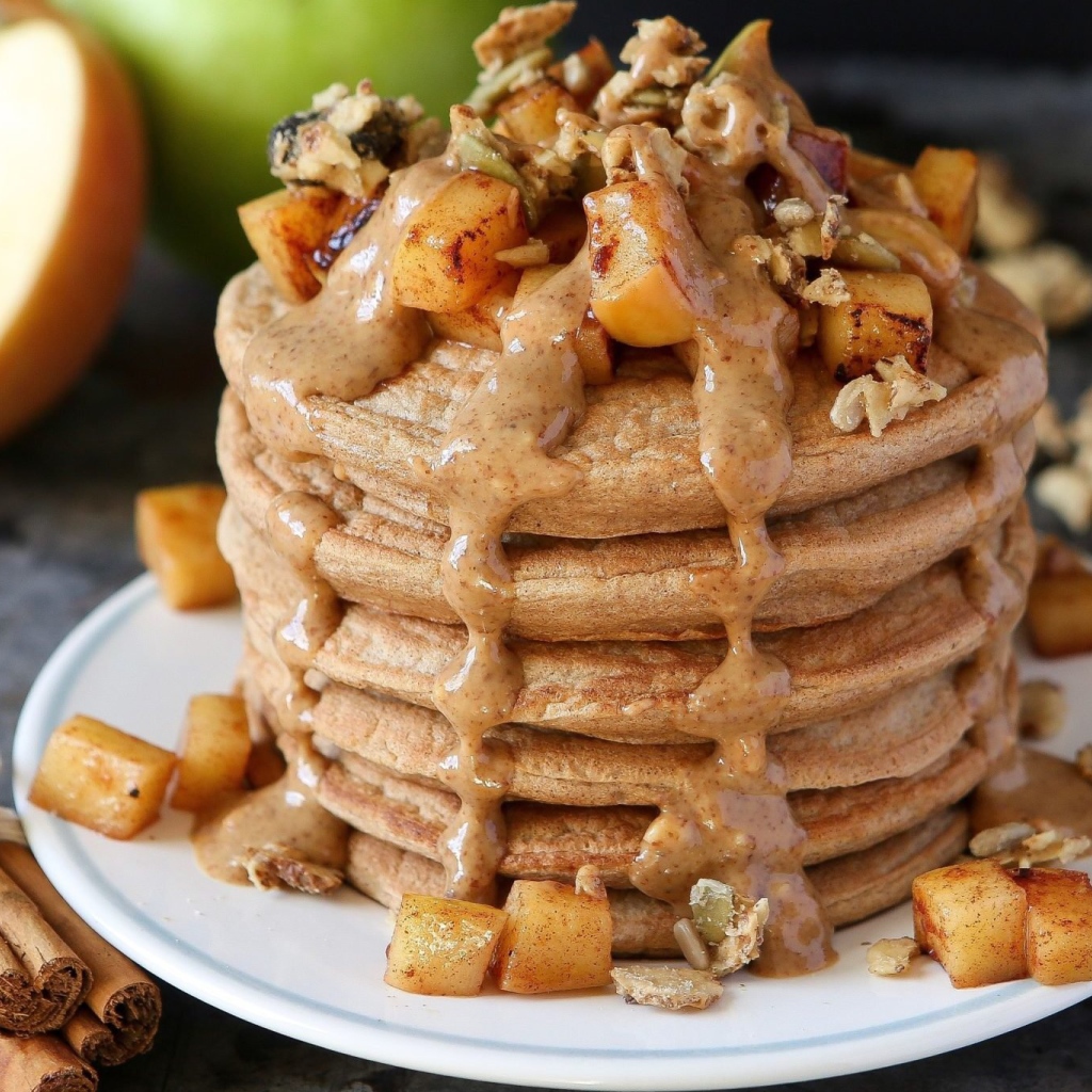 Вкусные оладьи с соусом и фруктами на столе с корицей