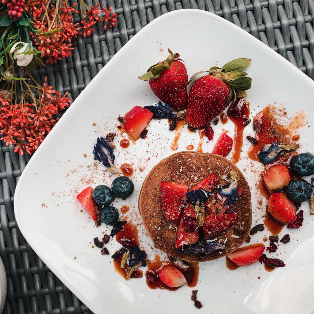 Десерт на белой тарелке с ягодами 