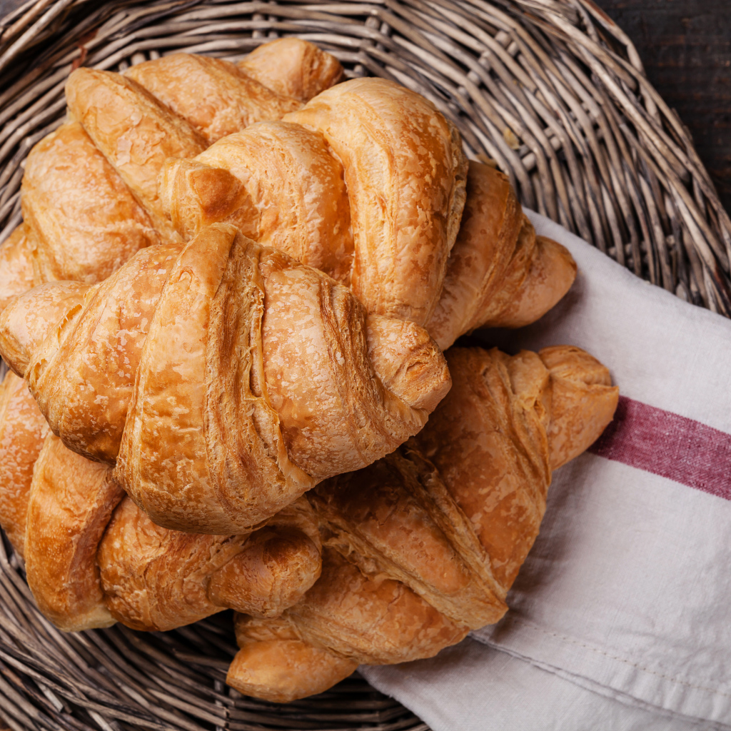 Свежие круассаны в корзинке с полотенцем