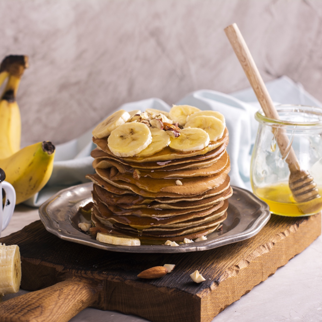 Оладьи с медом и бананами на столе