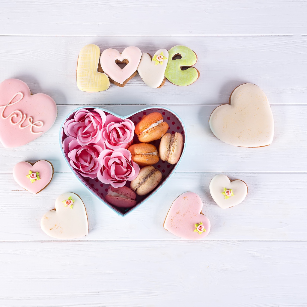 Печенье в форме сердца на столе с коробкой с десертом макарун