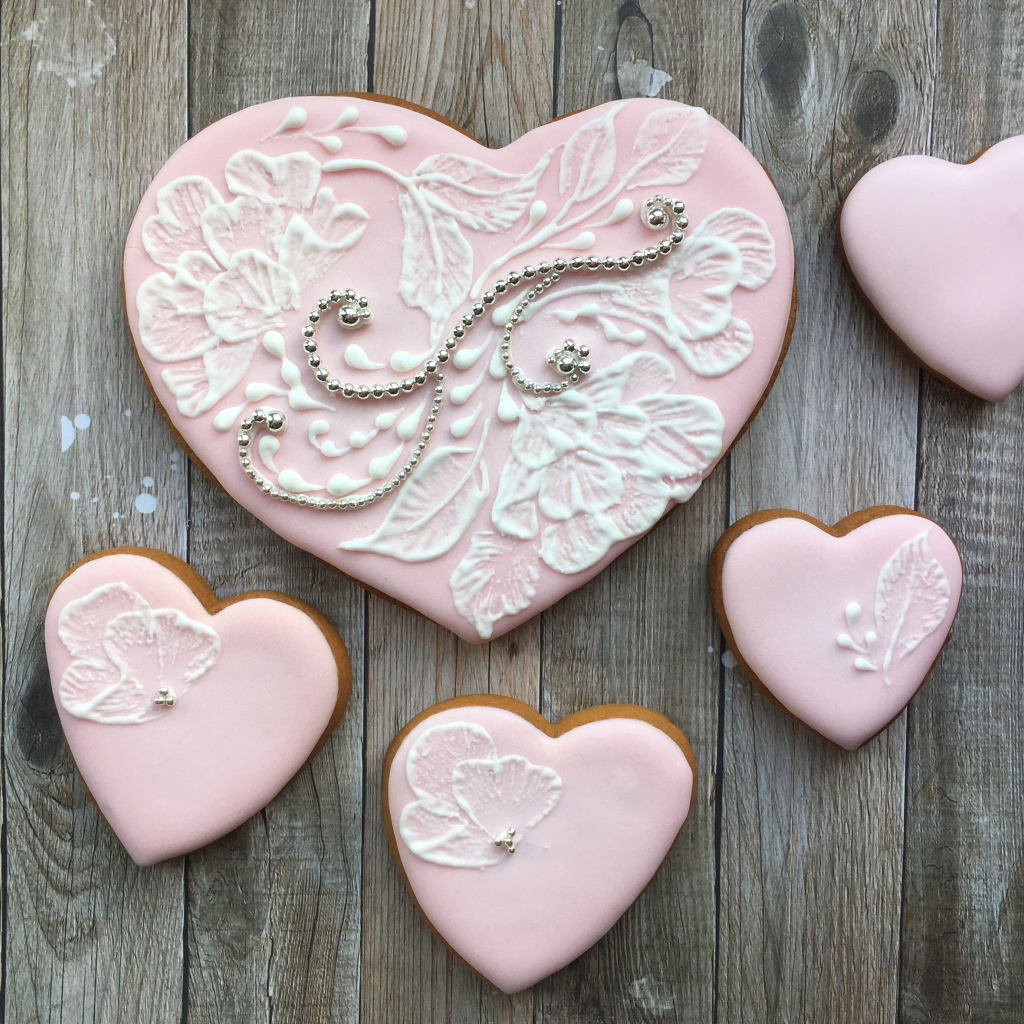 Печенье в форме сердца с розовой глазурью на столе