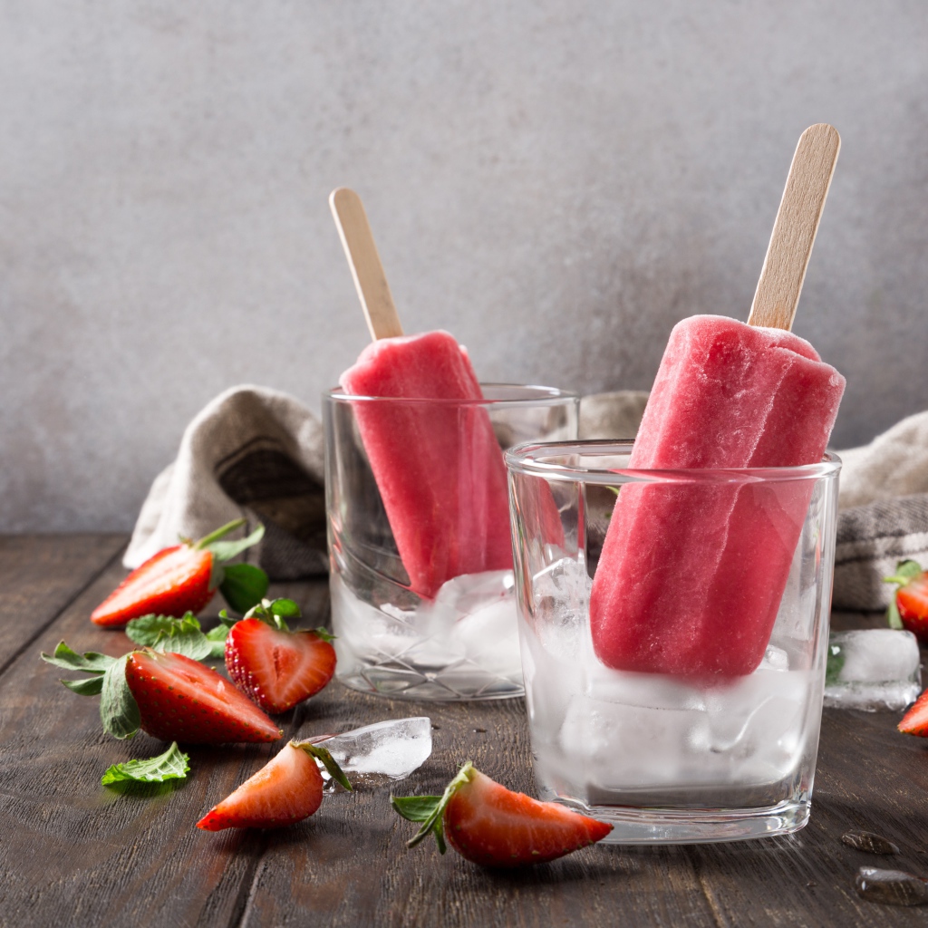 Фруктовое мороженое в стакане со льдом на столе с клубникой