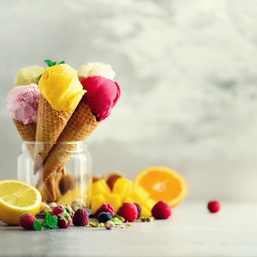 Фруктовое мороженое в вафельных рожках на столе с ягодами и фруктами