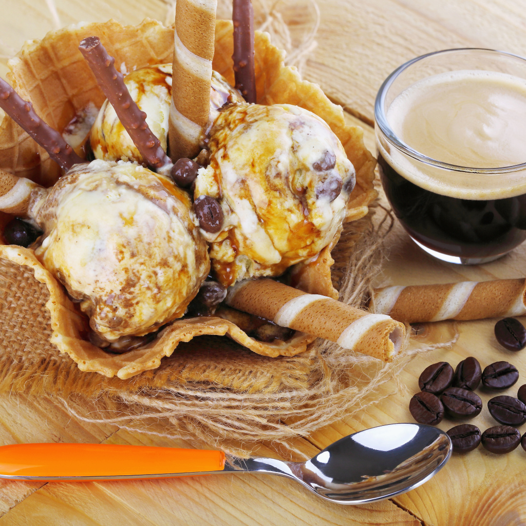 Мороженое с трубочками на столе с кофейными зернами и кофе