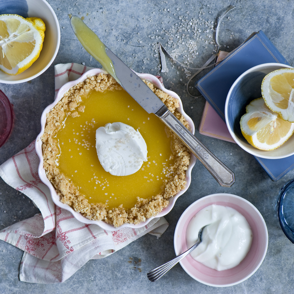 Лимонный пирог на столе с лимонами и сметаной