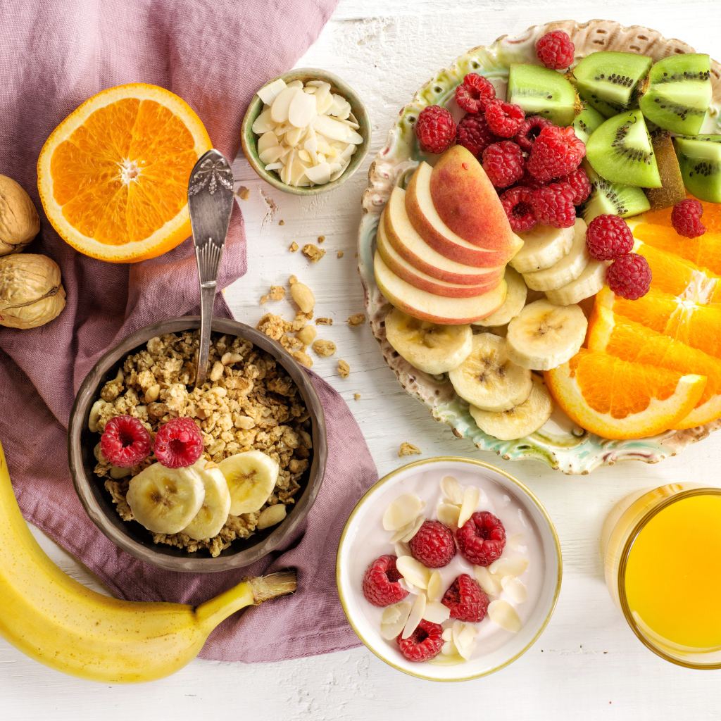 Мюсли на столе фруктами и соком к завтраку