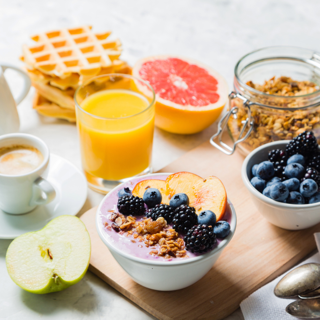 Мюсли с ягодами на столе с соком и кофе