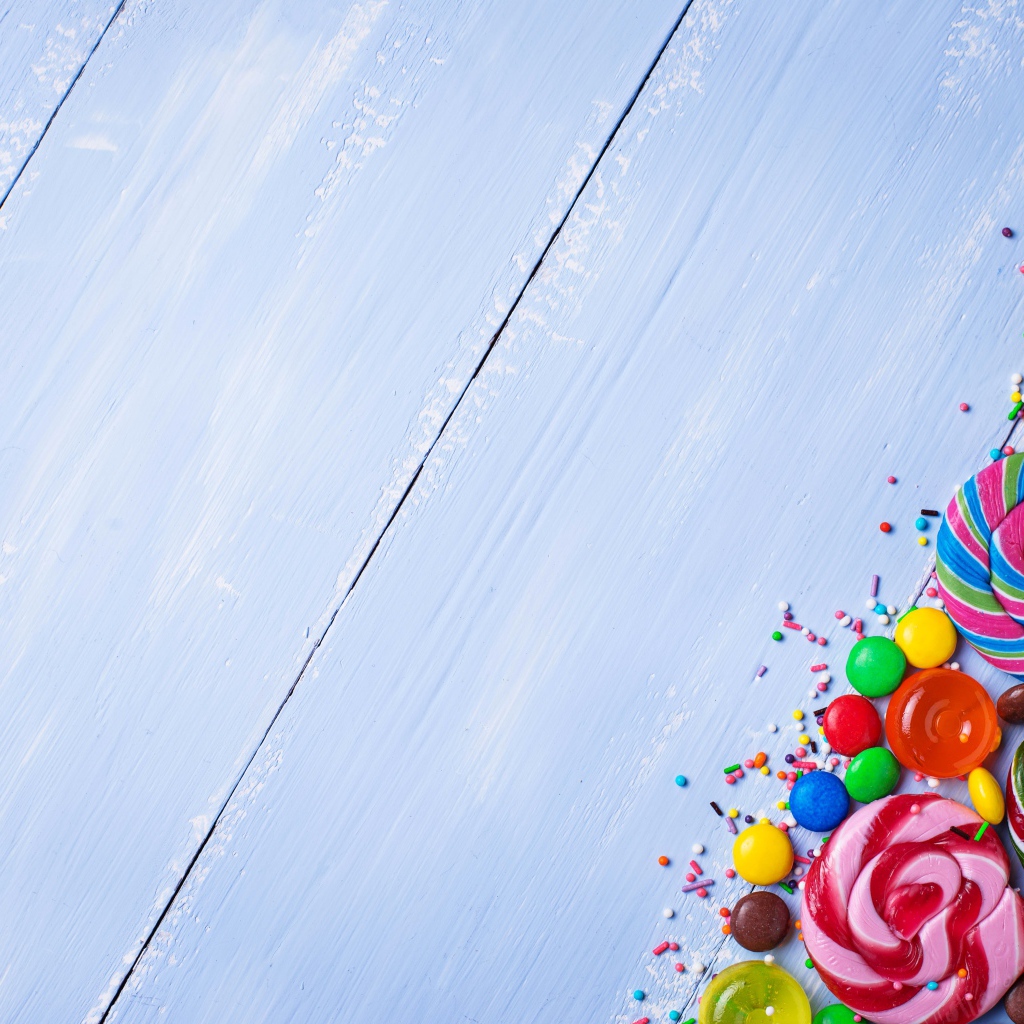 Разноцветные конфеты на голубом столе