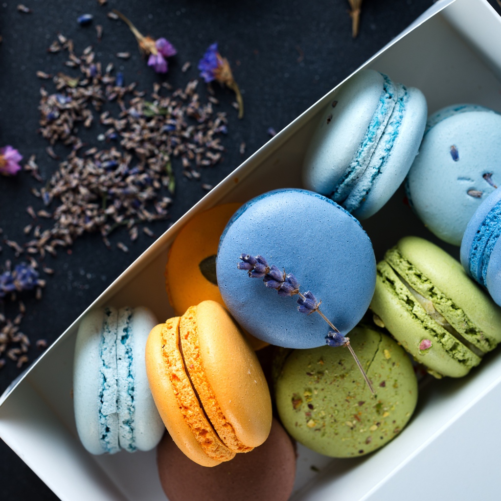 Разноцветный десерт макарон в коробке на столе с лавандой