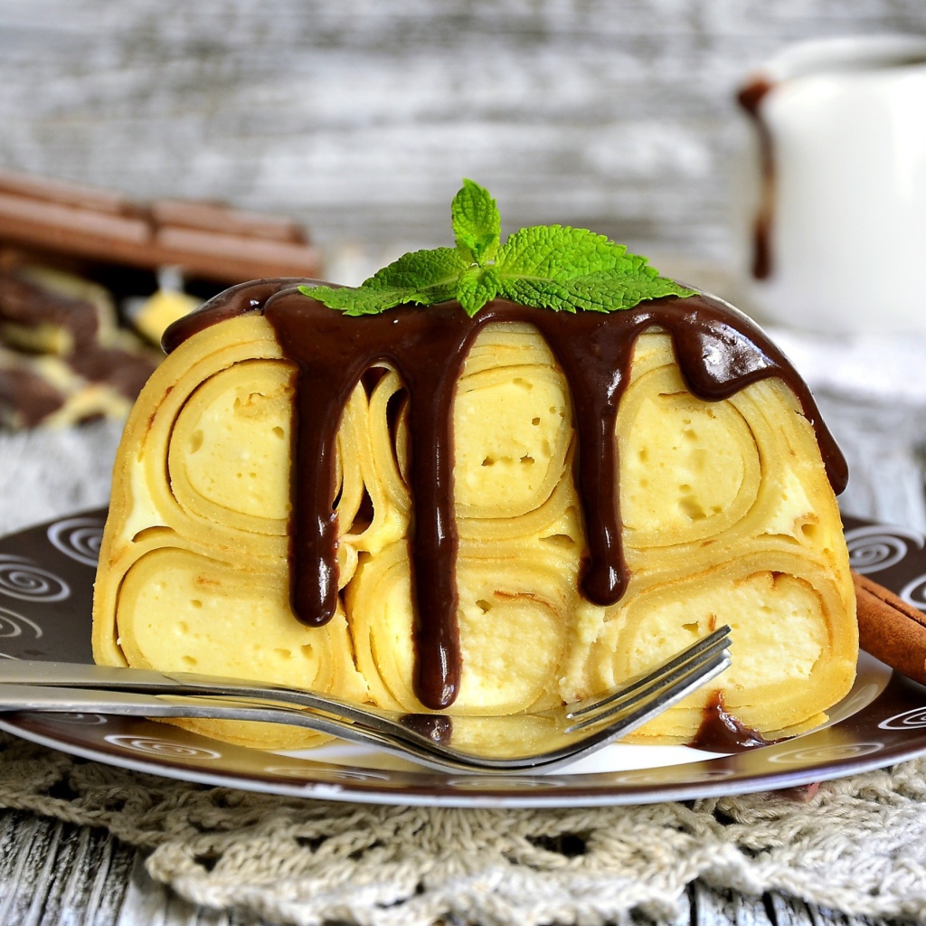 Блинный торт с творогом и шоколадом на тарелке 