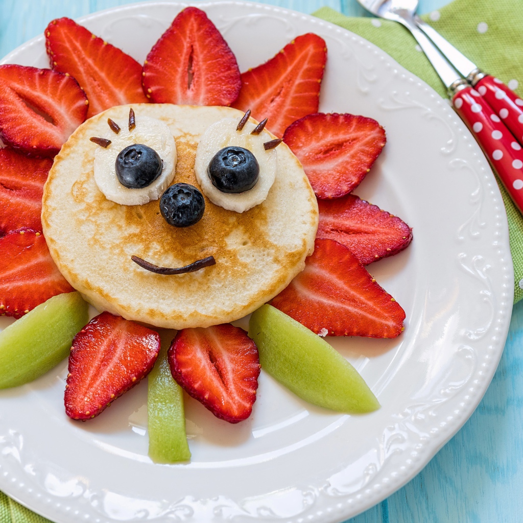 Оладьи с фруктами и ягодами на тарелке