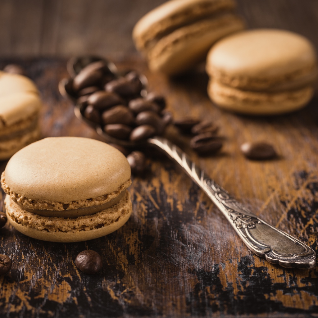Печенье макарон на столе с ложкой и кофейными зернами
