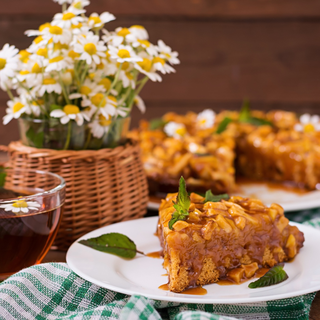 Пирог на столе с чаем и букетом ромашек