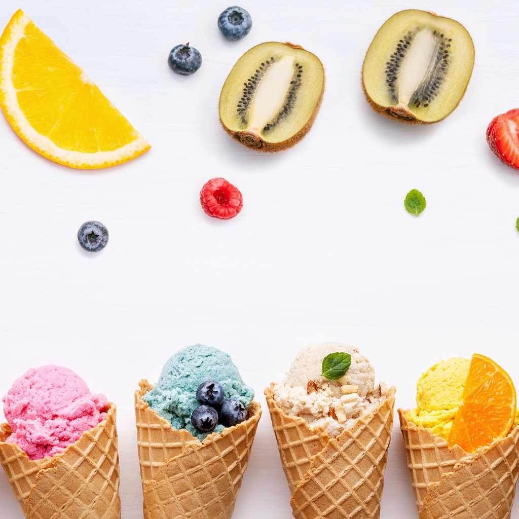Фруктовое мороженое в вафельных рожках на белом фоне с ягодами