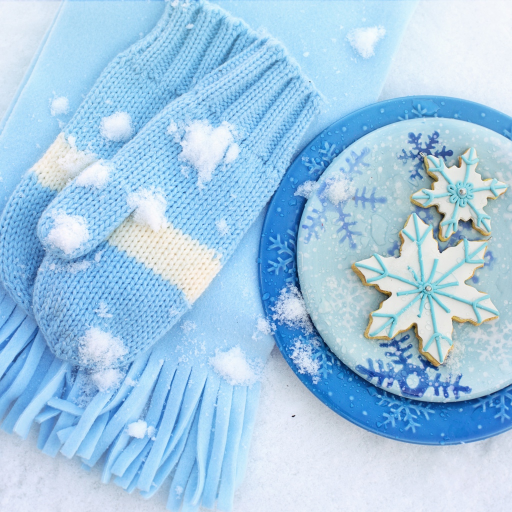 Печенье снежинки на снегу с шарфом и рукавицами