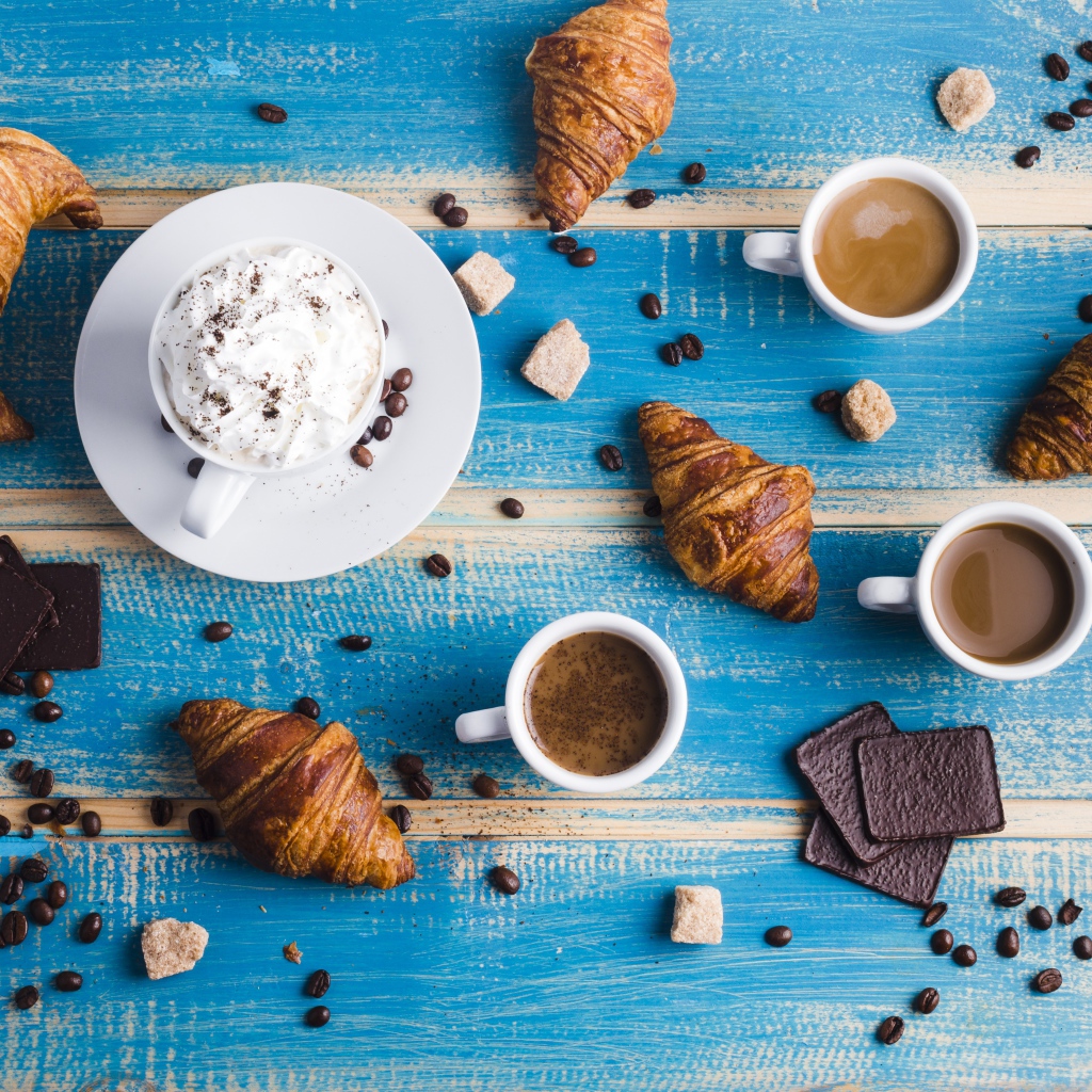 Сладости с кофе на голубом столе