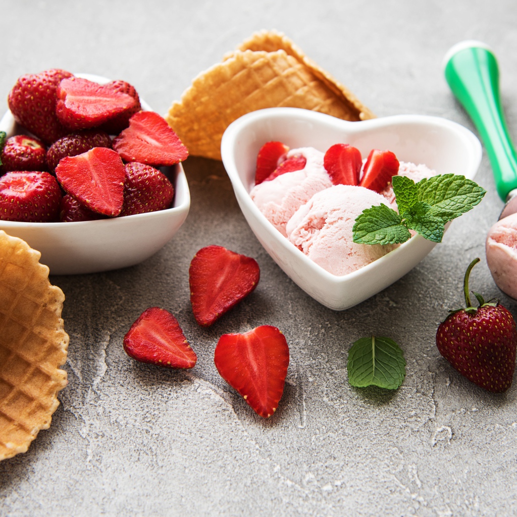 Вкусное мороженое на столе с клубникой и вафельными рожками
