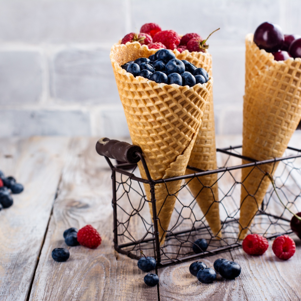 Два вафельных рожка на столе с ягодами