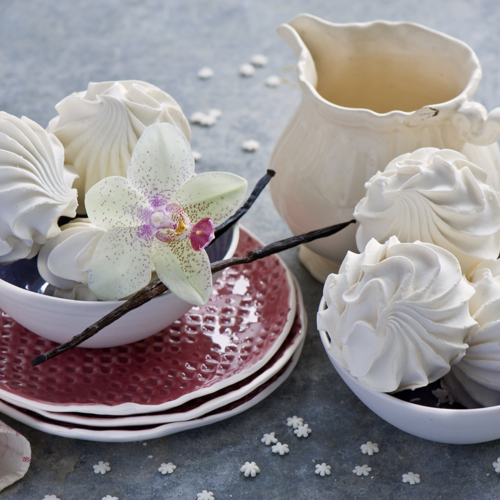 Белый зефир на столе с цветком орхидеи