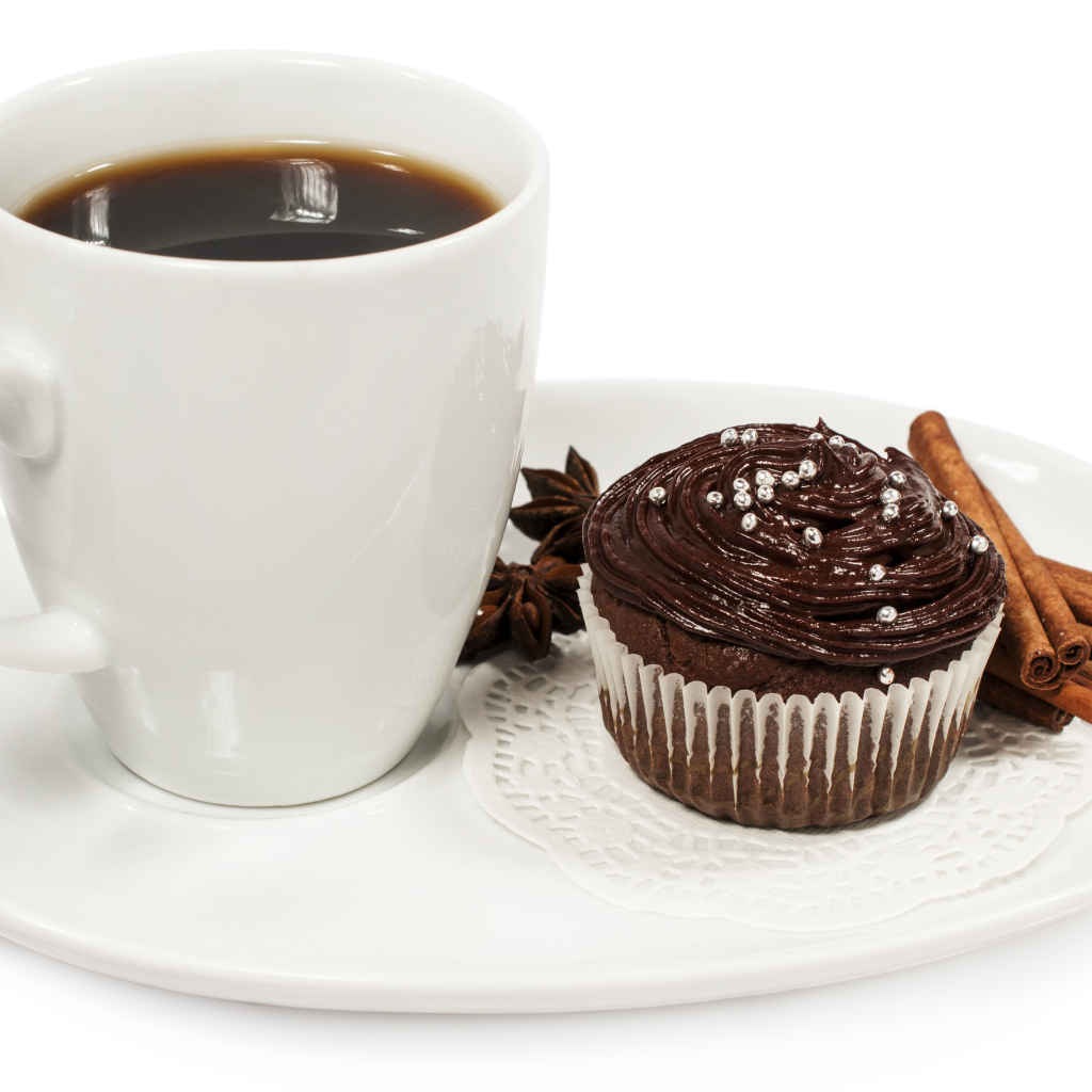 Чашка кофе на белой тарелке с кексом и корицей