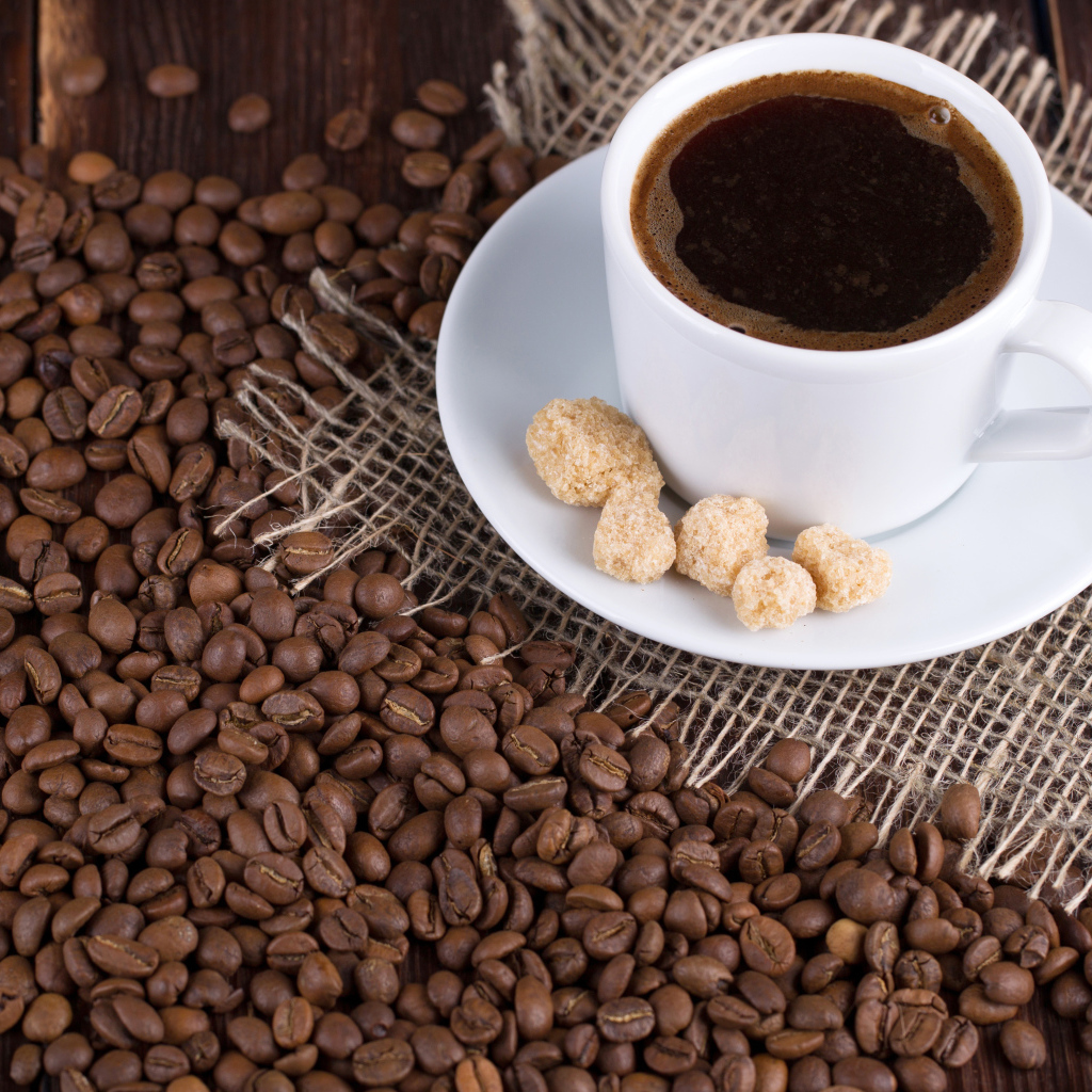 Чашка кофе с зернами на столе 