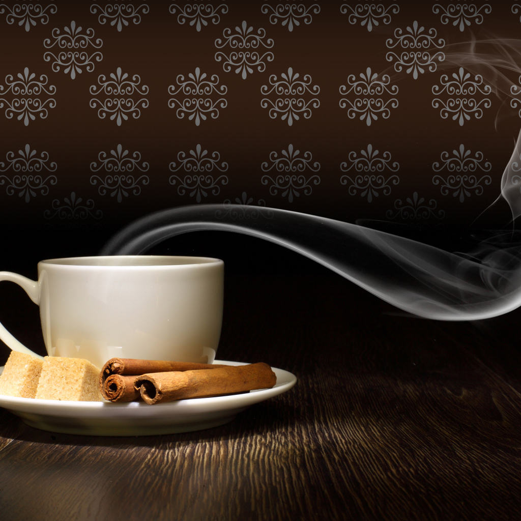 Чашка горячего кофе с дымом на блюдце с сахаром и корицей