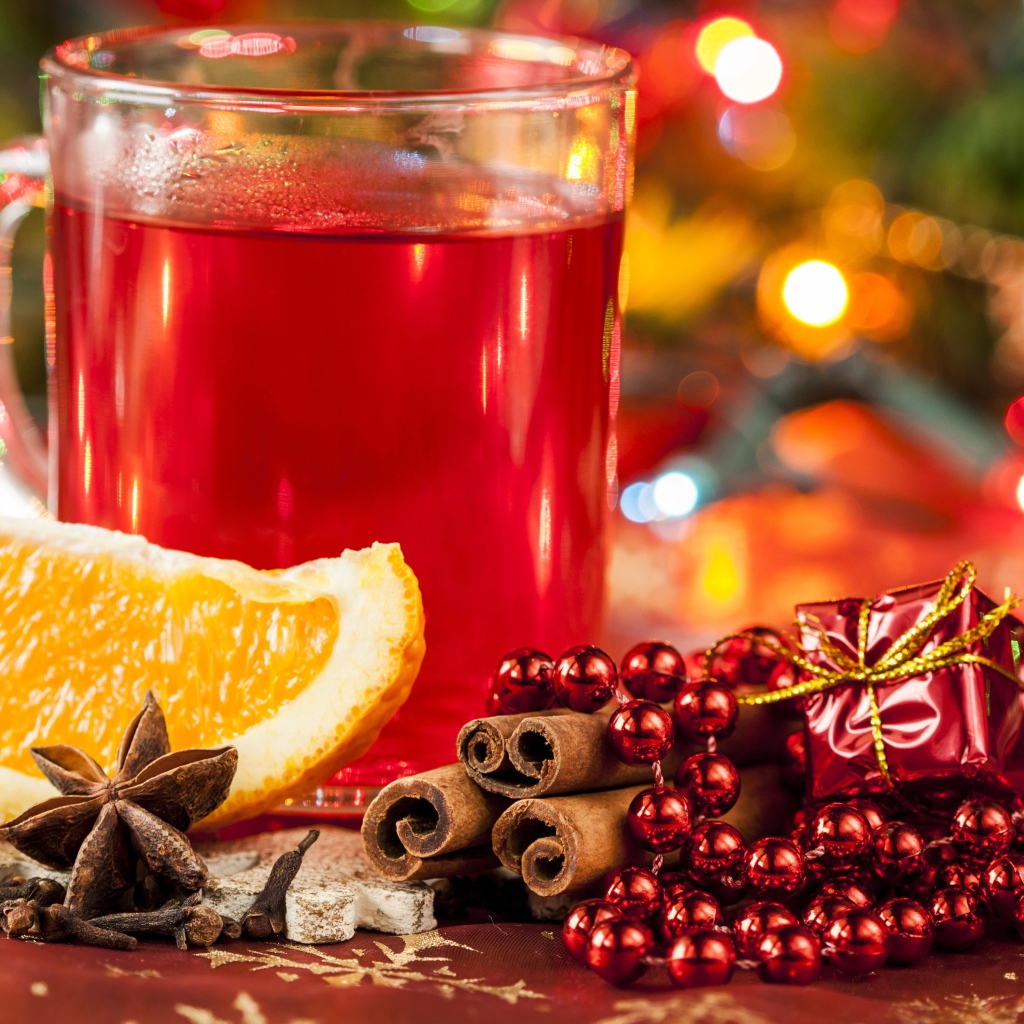 Чашка горячего чая на столе с корицей, бадьяном и кусочком апельсина 