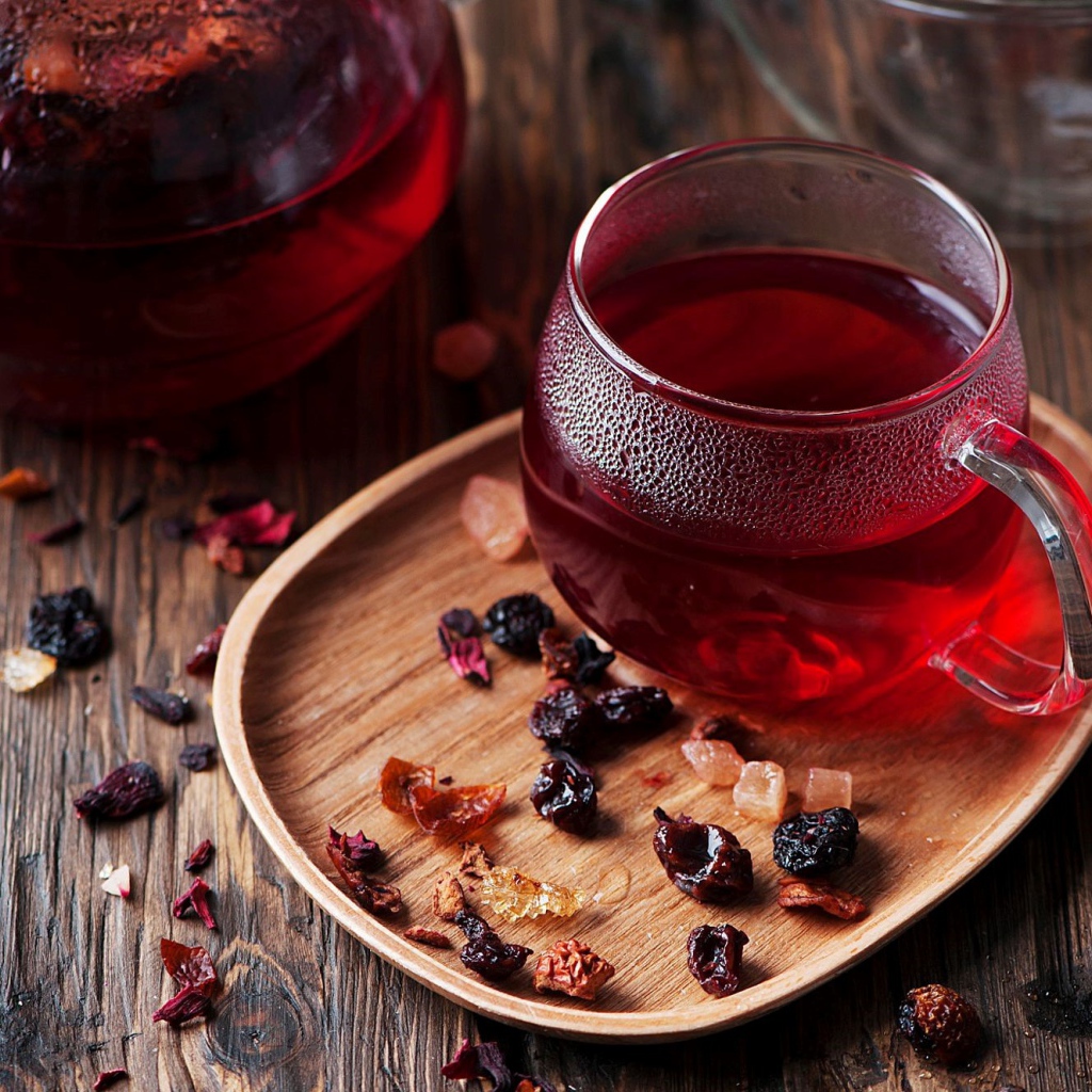 Стеклянная чашка горячего красного чая с сухофруктами 
