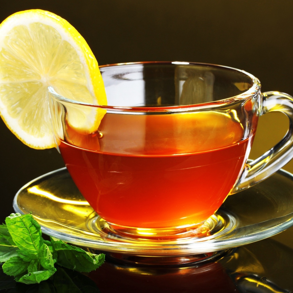 Стеклянная чашка чая с лимоном и листьями мяты