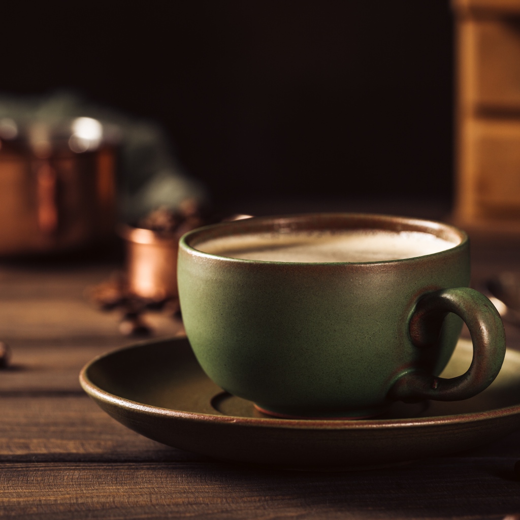 Большая чашка кофе на столе с кофейными зернами 