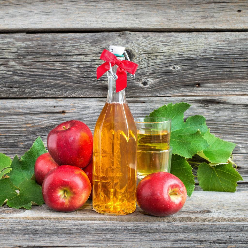 Яблочный сок на столе с красными яблоками