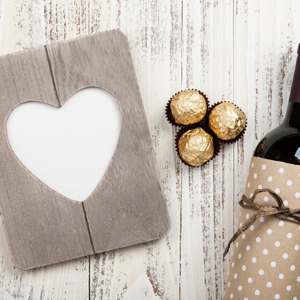 Бутылка вина на столе с конфетами и сердцем 