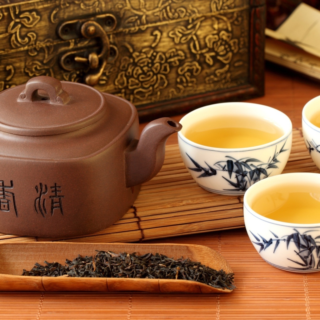 Китайский чайник на столе с чашками