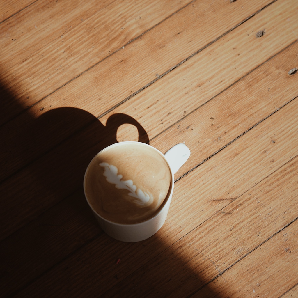 Чашка капучино с рисунком на деревянном столе