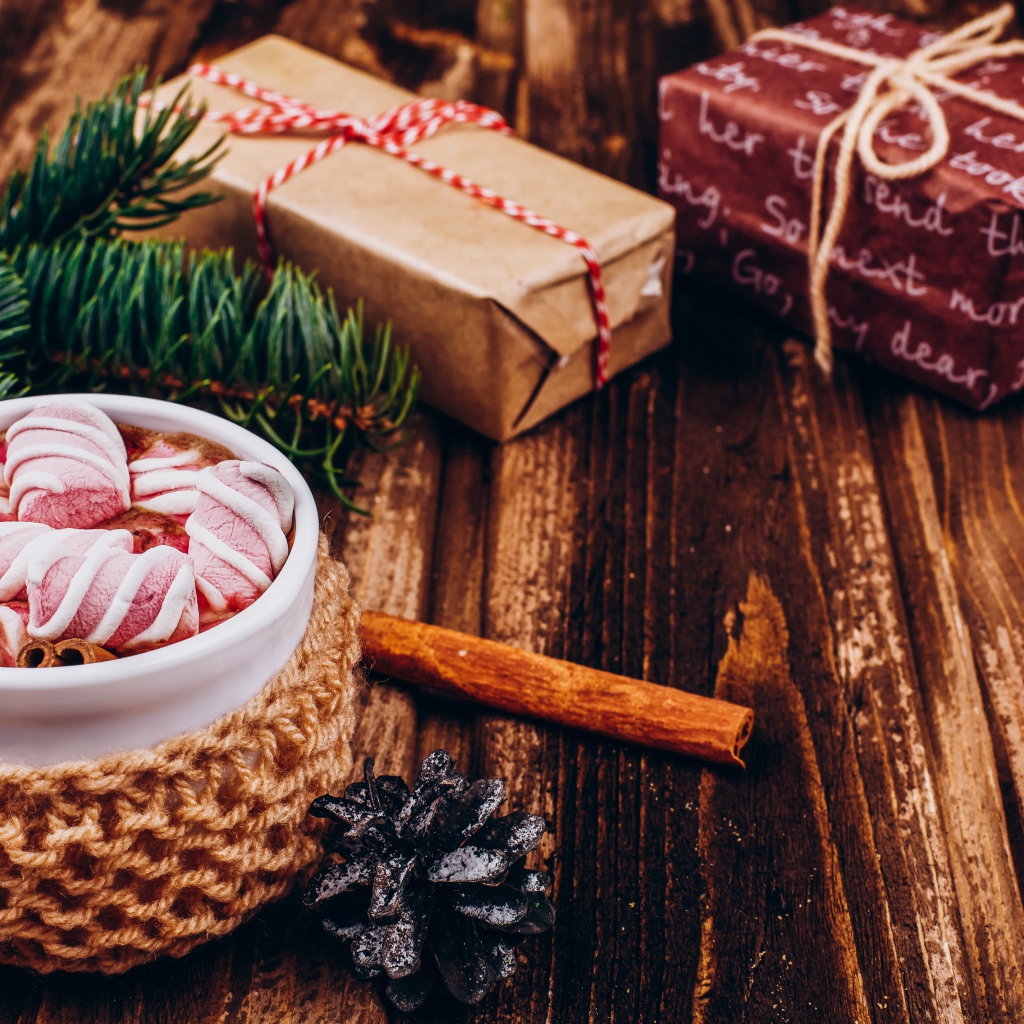 Чашка какао с маршмеллоу на столе с подарками