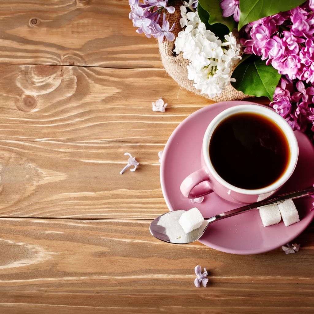 Чашка кофе на деревянном столе с сиренью 