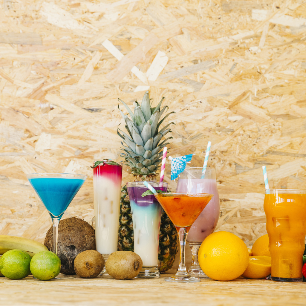 Разные коктейли на столе с фруктами 