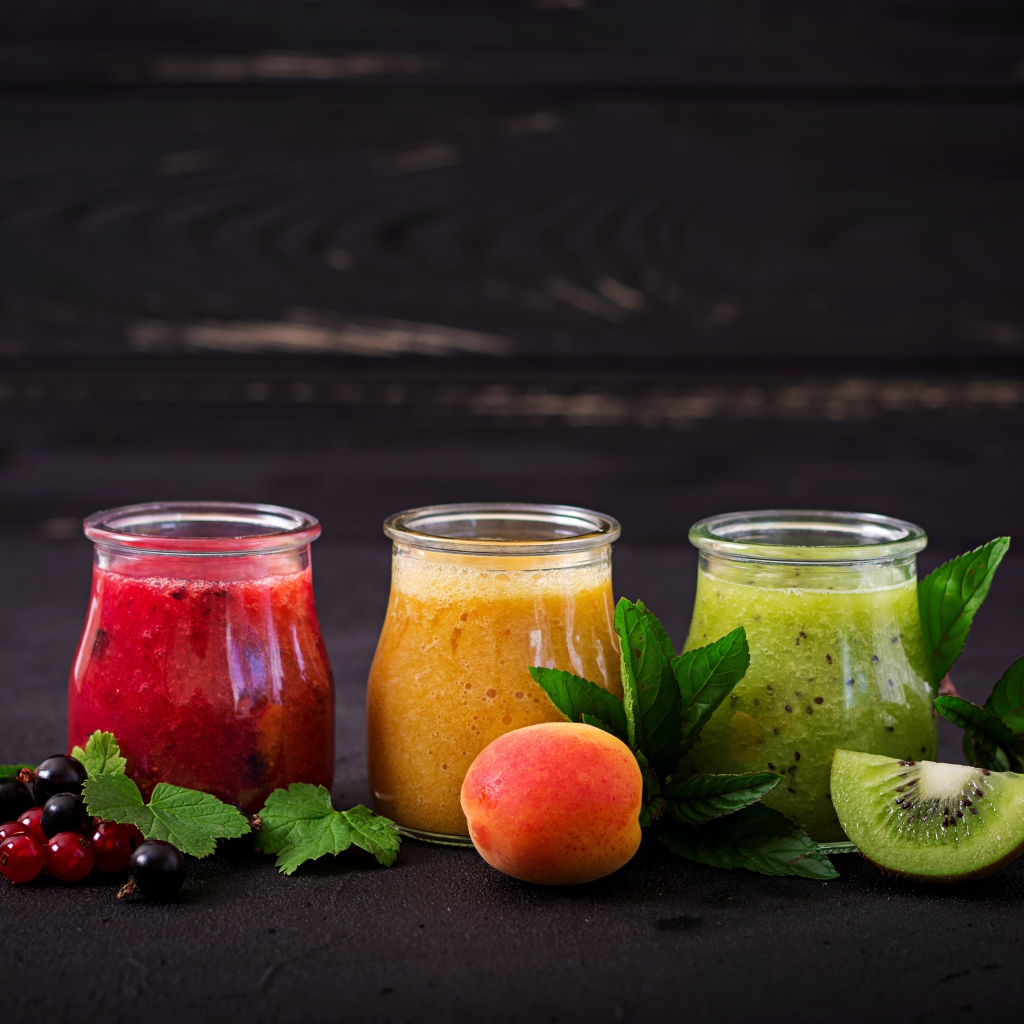 Фруктовое смузи в баночках на столе 