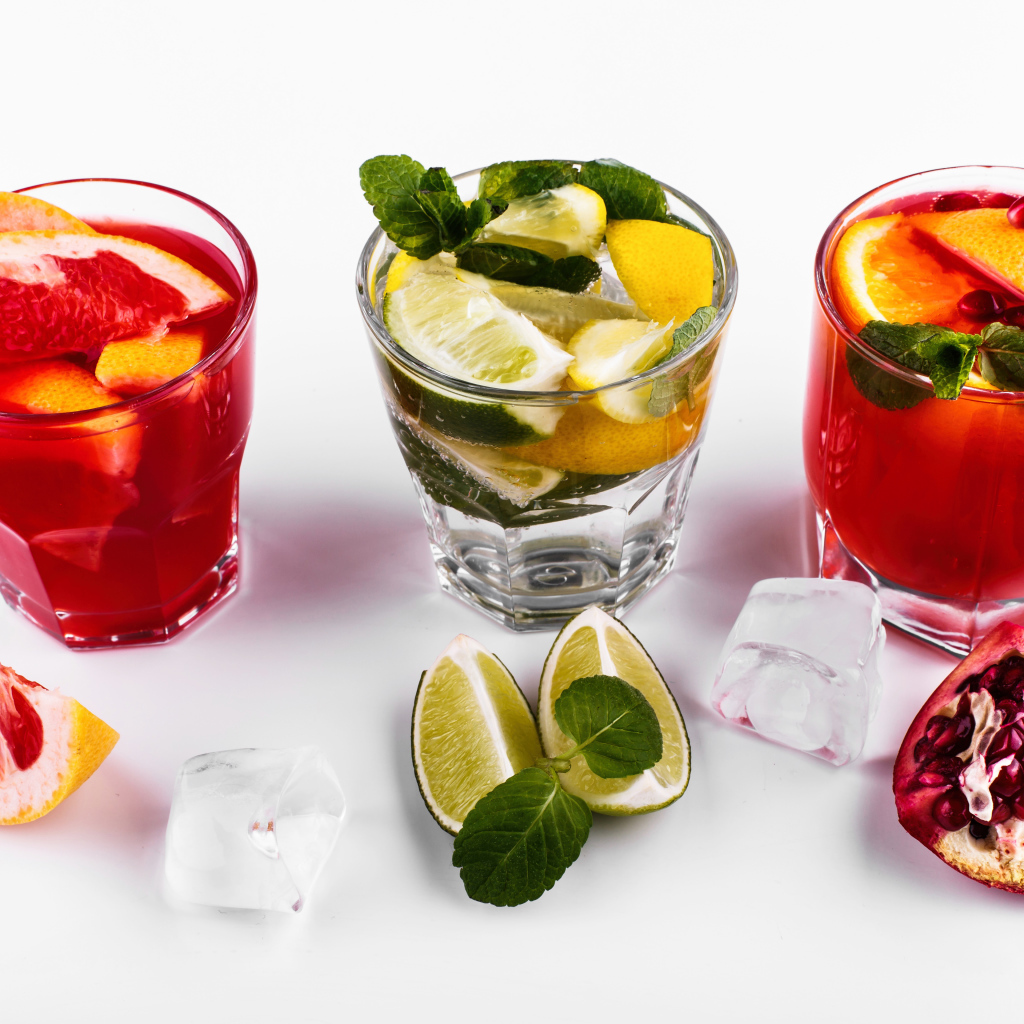 Glasses with citrus cocktails with ice on a white background with fruit
