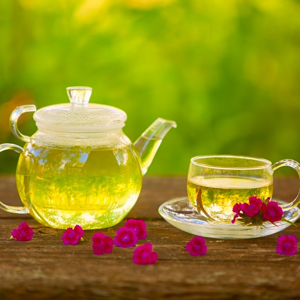 Зеленый чай на столе в стеклянном чайнике и чашке