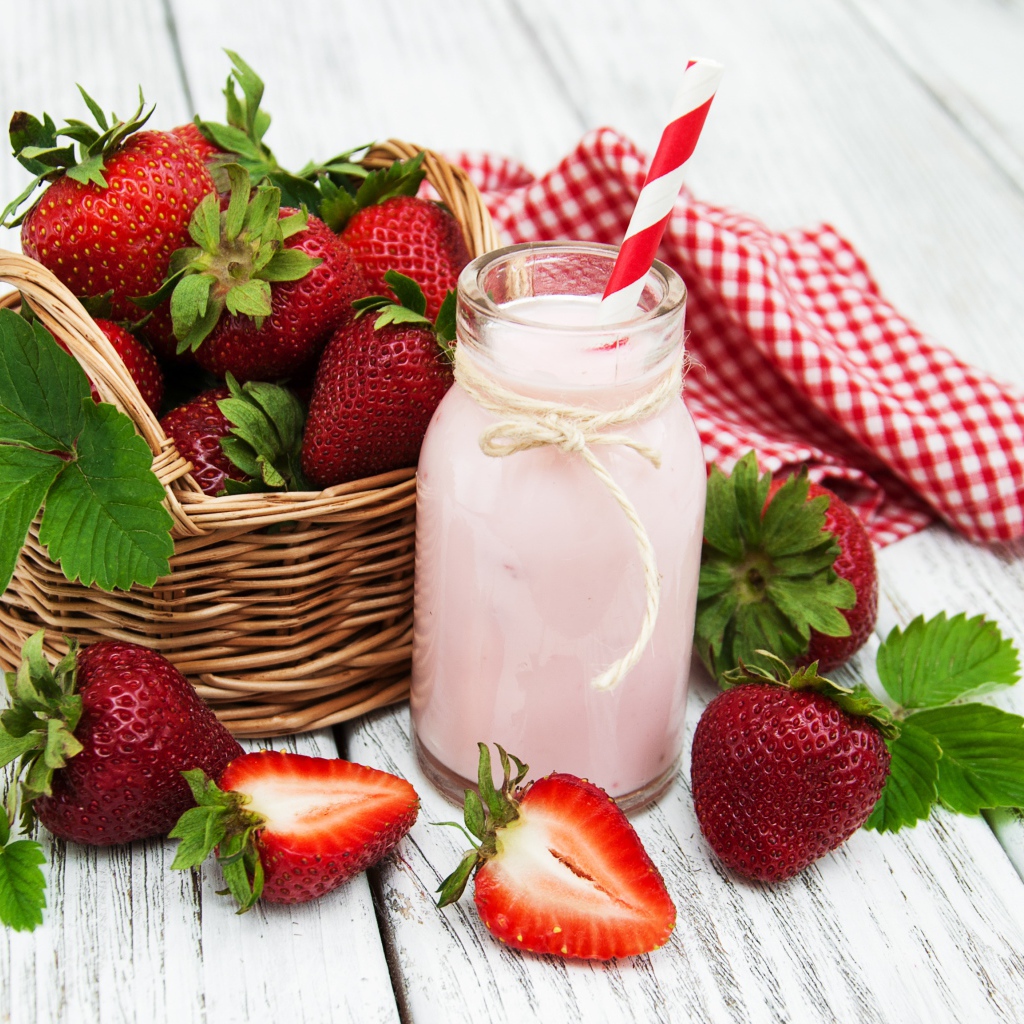 Банка с коктейлем на столе с ягодами клубники