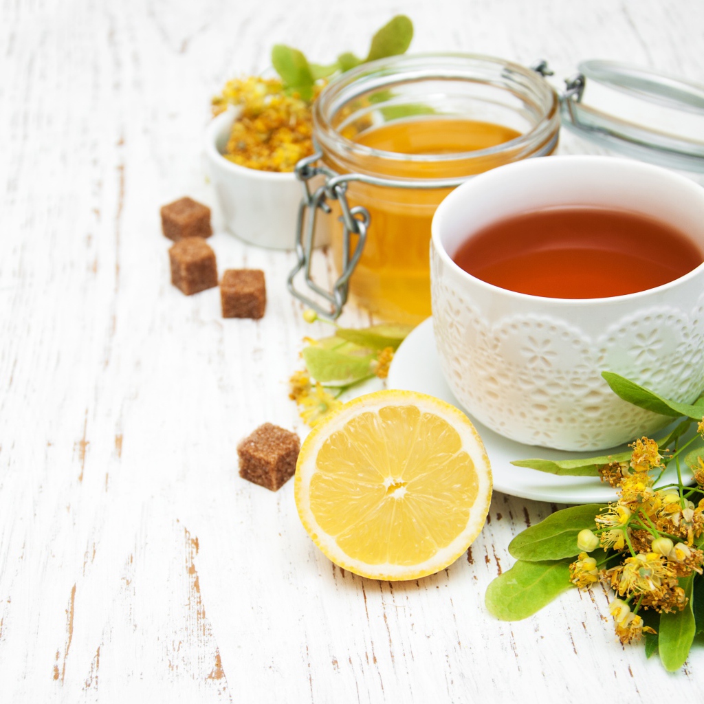 Липовый чай на столе с медом, лимоном, и сахаром