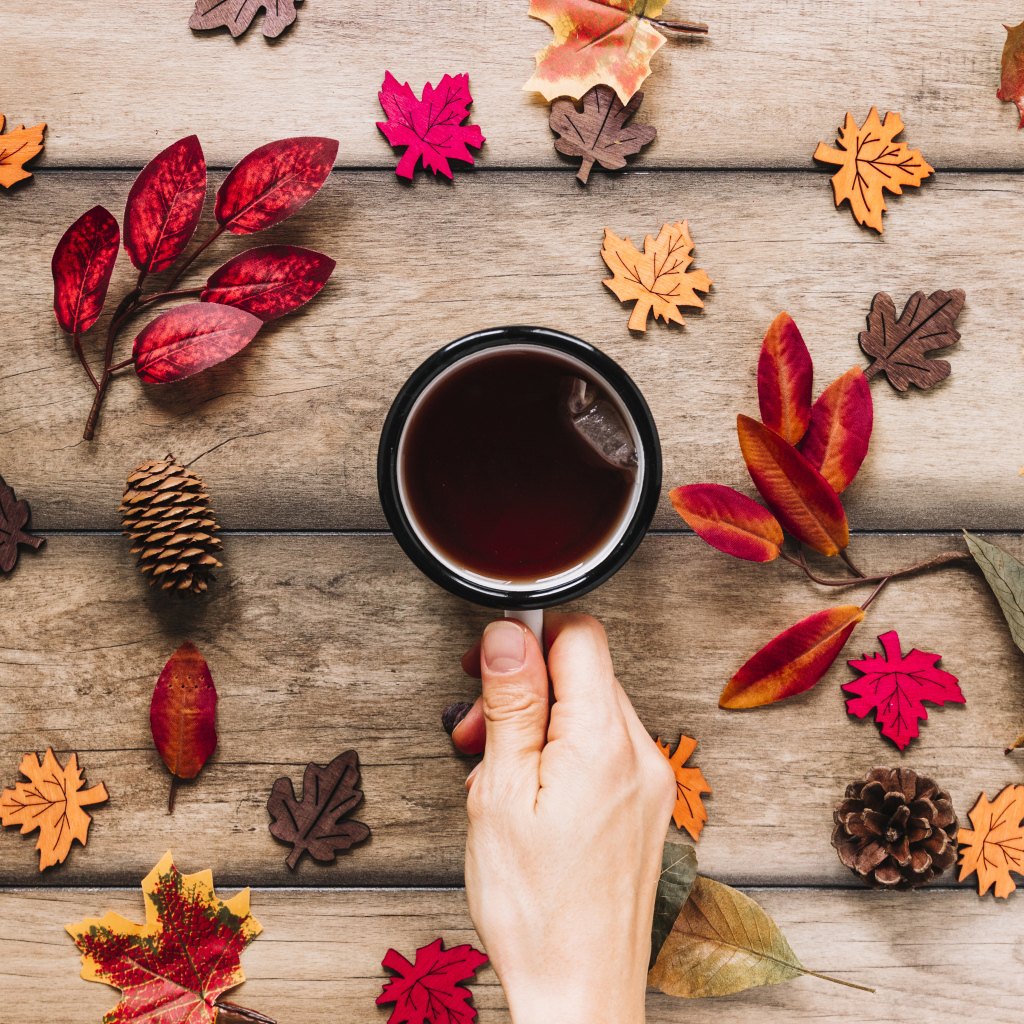 Кружка чая на столе с осенними листьями