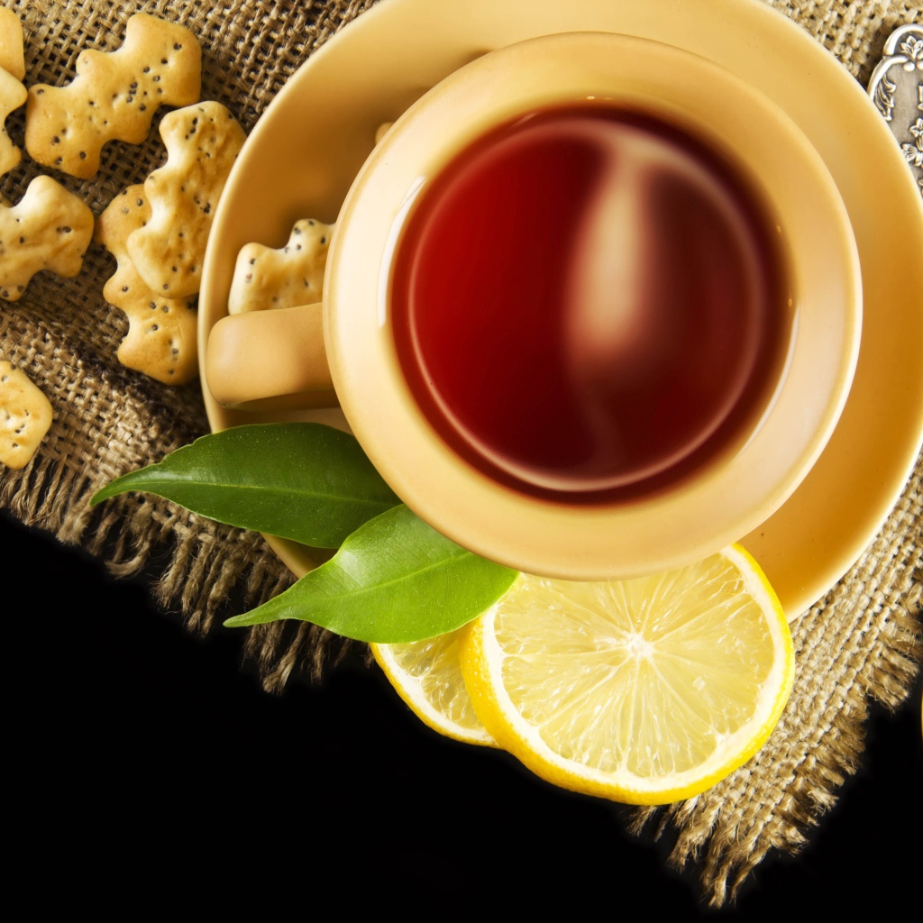 Чай на столе с печеньем и кусочками лимона