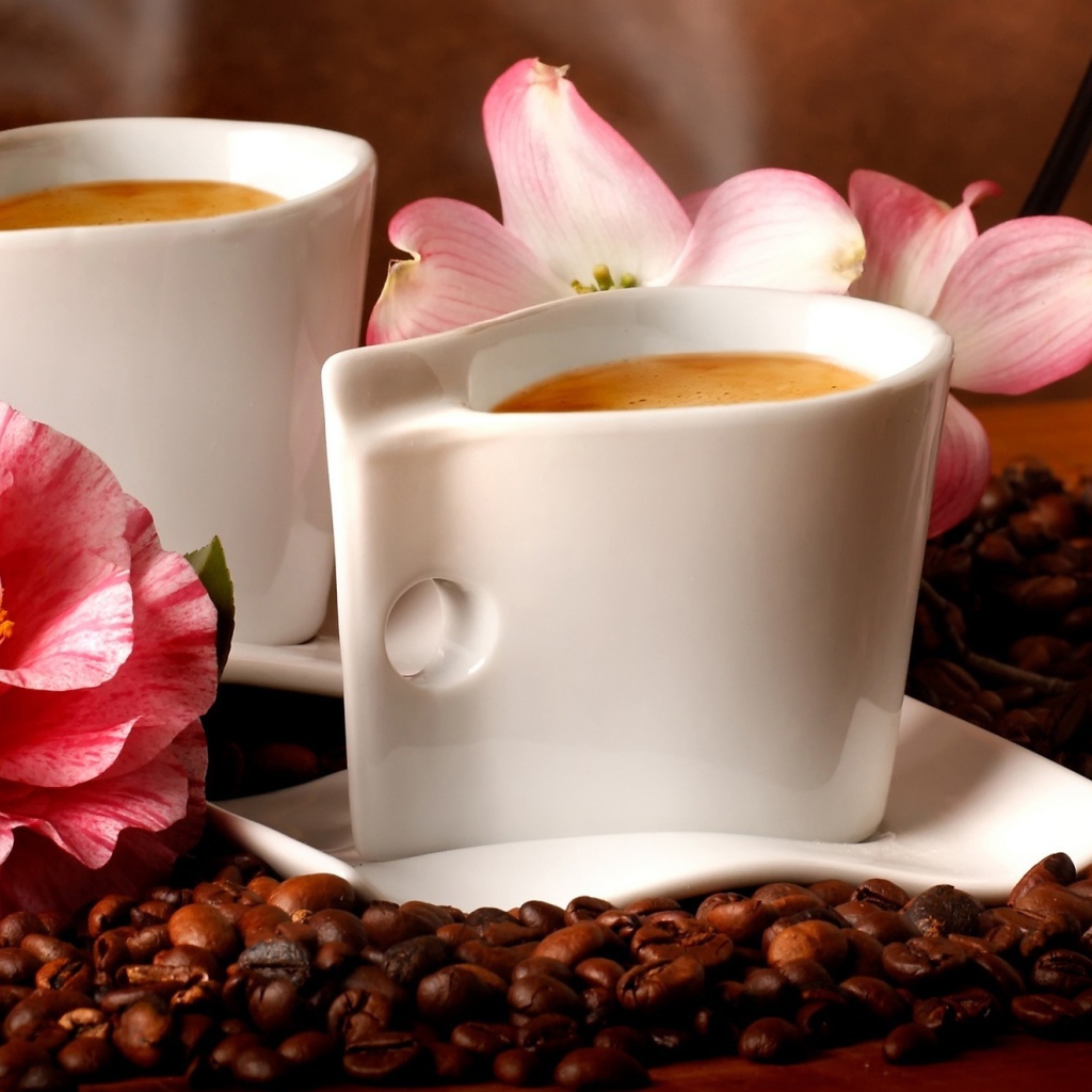 Две чашки кофе на столе с кофейными зернами и цветами