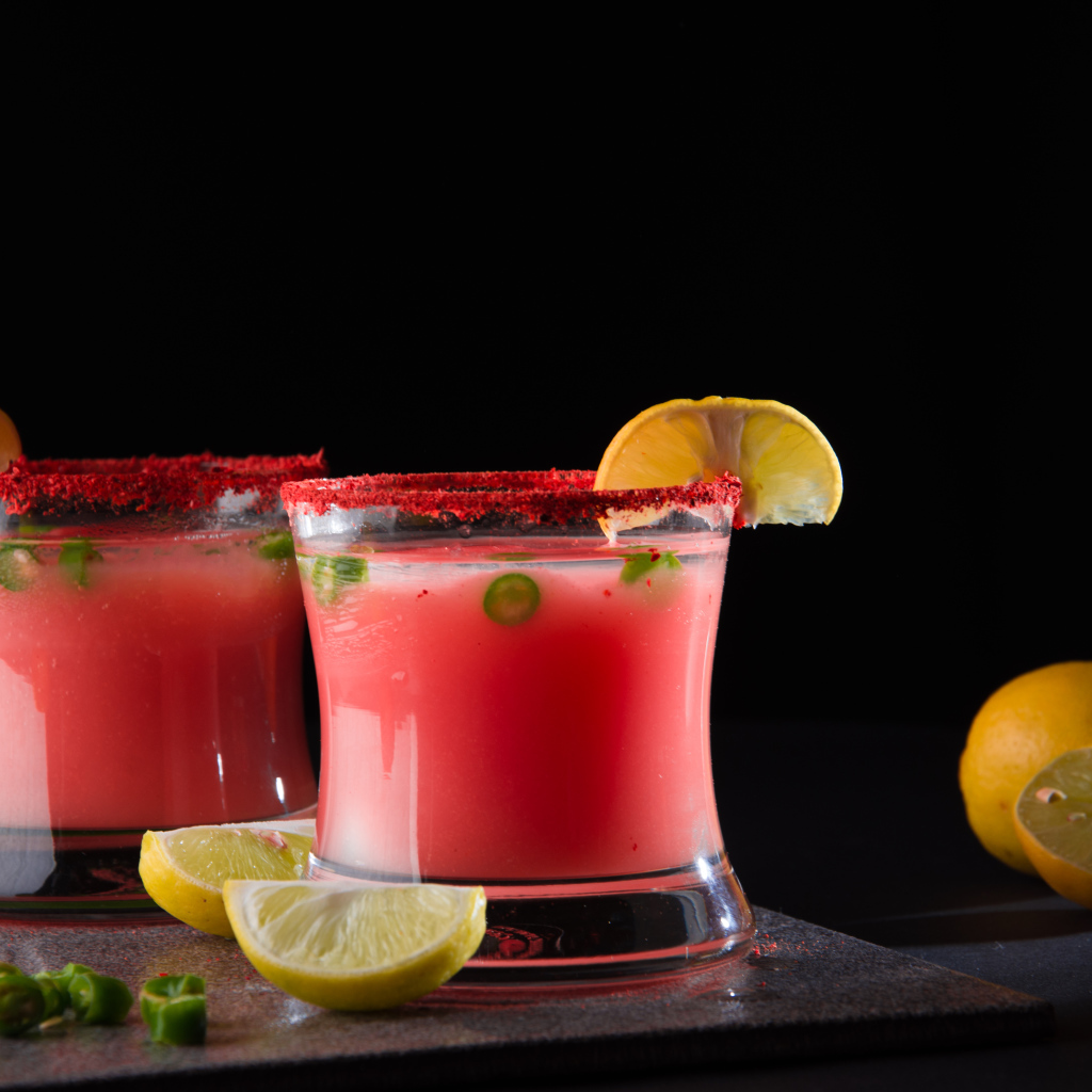 Два стакана с коктейлем на черном фоне с лимоном