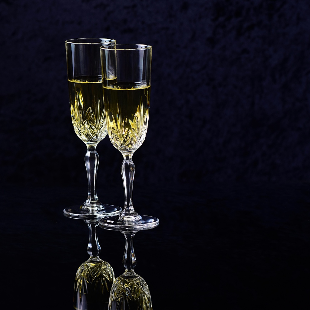 Два бокала с шампанский на черном фоне