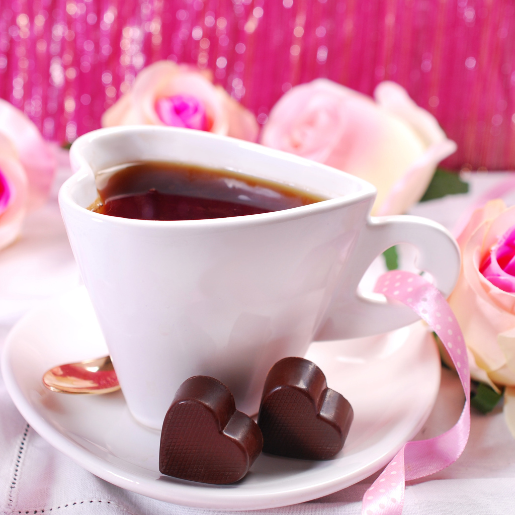 Белая чашка в форме сердца с кофе на блюдце с конфетами